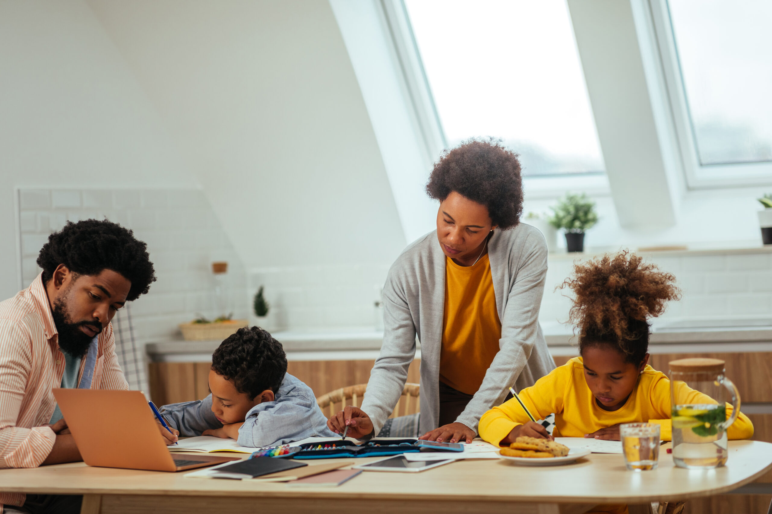 Parents helping their children study together at a table